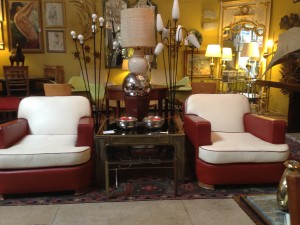 A couple of stylish Art Deco club chairs sit among an eclectic mix of furniture, wall hangings and more at Little Paris Antiques. 