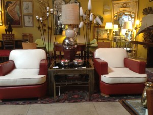 A couple of stylish Art Deco club chairs sit among an eclectic mix of furniture, wall hangings and more at Little Paris Antiques.